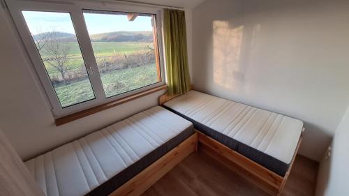 a bench in a room with a large window at Domek pod jabloní in Tichá