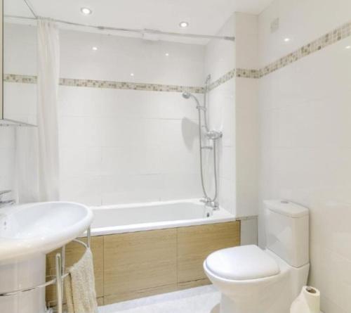 a bathroom with a tub and a toilet and a sink at Entire cosy Apartment in a quiet lovely area with parking in Wellingborough