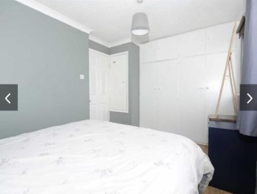a bedroom with a white bed and a window at Entire cosy Apartment in a quiet lovely area with parking in Wellingborough