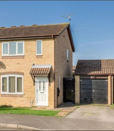 a brown brick house with a garage at Entire cosy Apartment in a quiet lovely area with parking in Wellingborough