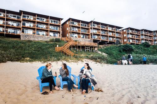 a group of people sitting in chairs on the beach at Hallmark Resort in Cannon Beach in Cannon Beach