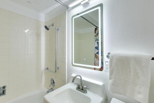 a white bathroom with a sink and a mirror at Studio in Gadsden about 10 Mi to the Coosa River! in Gadsden