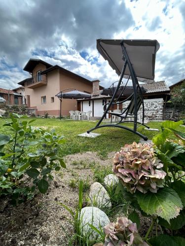 a view of a garden with a grill in the yard at Къща Цвети in Dobrinishte
