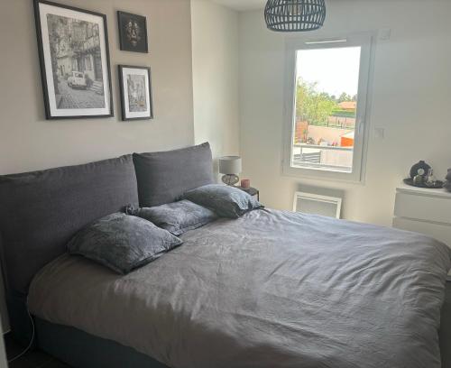 - un lit dans une chambre avec des oreillers dans l'établissement Maison Port de bouc, à Port-de-Bouc