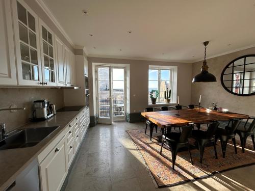 a kitchen with a wooden table and a dining room at Wonderful 3-bedroom APT in heart of Visby in Visby