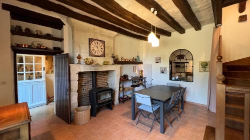 une salle à manger avec une table et une cheminée dans l'établissement Gîte Hurlevent, à Azay-le-Rideau