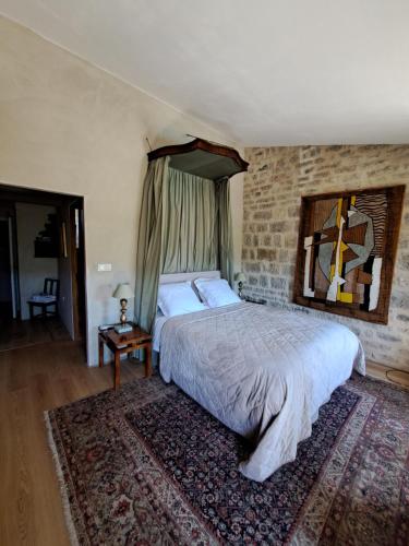 une chambre avec un grand lit et un mur de briques dans l'établissement Chateau de Sainte Jalle, à Sainte-Jalle