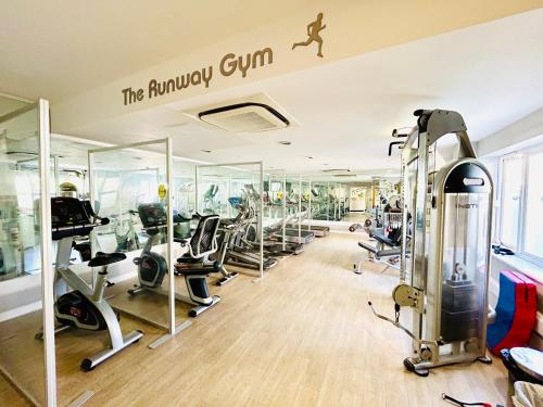 a gym with treadmills and cardio equipment in a room at Heathrow Apartment with Parking & Gym in West Drayton