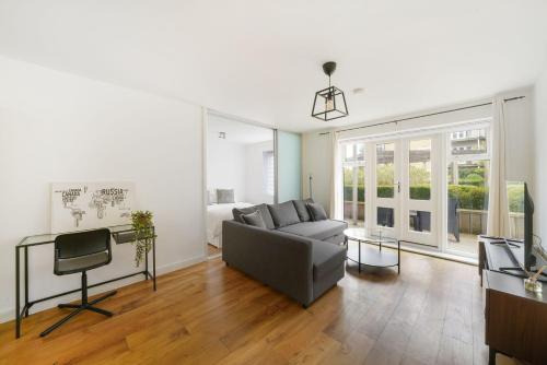 a living room with a couch and a television at Heathrow Apartment with Parking & Gym in West Drayton