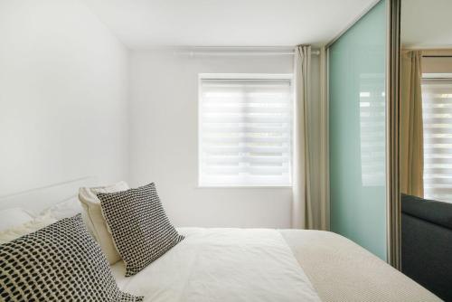 a bedroom with a bed and a window at Heathrow Apartment with Parking & Gym in West Drayton
