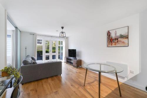 a living room with a couch and a glass table at Heathrow Apartment with Parking & Gym in West Drayton