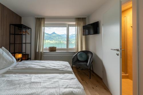 ザンクト・ヴォルフガングにあるEden Apartments Vista Lagoのベッドと椅子と窓のある寝室