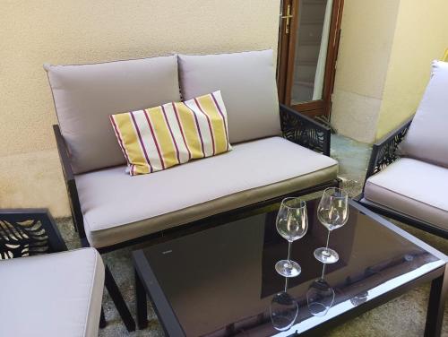 un canapé et deux verres à vin sur une table dans l'établissement Jolie maison avec jardin clos - Fontainebleau Héricy, 35 min Paris, à Héricy