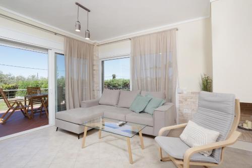a living room with a couch and a glass table at Toroneos Sea Side Villa in Paliouri
