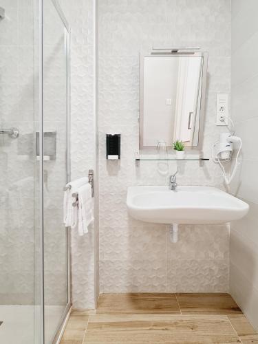 a white bathroom with a sink and a shower at Bilbao ROOMS & KITCHEN Santutxu in Bilbao