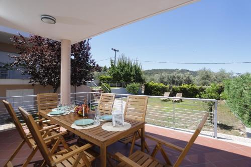 a wooden table and chairs on the patio of a house at Toroneos Sea Side Villa in Paliouri
