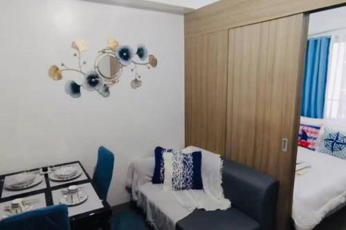 a room with a bed and a chair and a chandelier at E & R Staycation Condotel near Mall of Asia in Manila