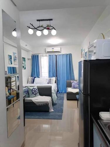 a living room with a couch and a refrigerator at E & R Staycation Condotel near Mall of Asia in Manila