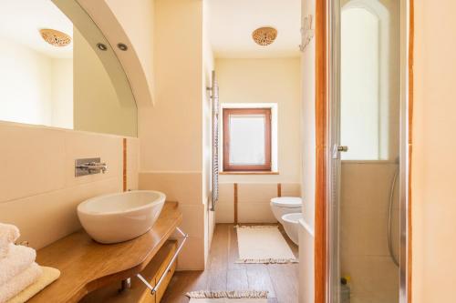 a white bathroom with a sink and a toilet at North Sardinia Retreats Stazzo Liccia Barria - villa con piscina in Arzachena