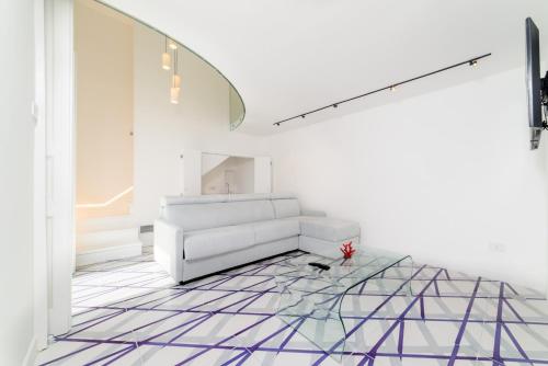 a living room with a white couch and a glass table at Palazzo Colavolpe Suite in Atrani