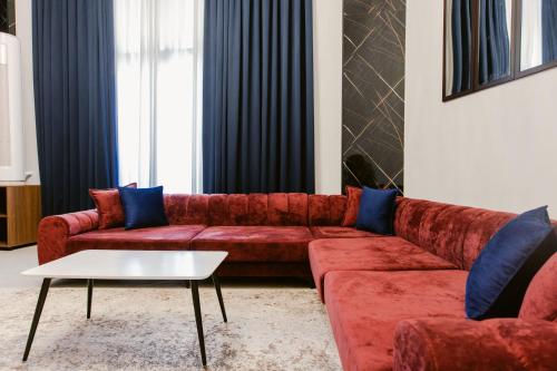 a living room with a red couch and blue pillows at Andor Luxury Hotel & Duplex in Durrës