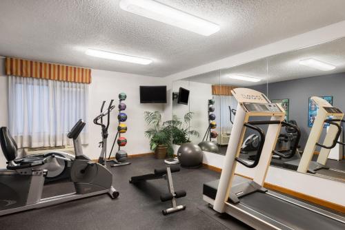 a gym with treadmills and exercise equipment in a room at Days Inn & Suites by Wyndham Kansas City - CHIEFS Stadium in Kansas City