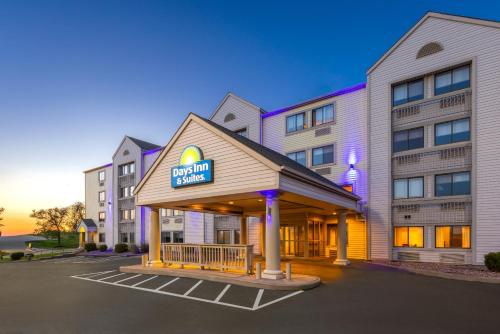 a hotel with a sign on the front of a building at Days Inn & Suites by Wyndham Kansas City - CHIEFS Stadium in Kansas City