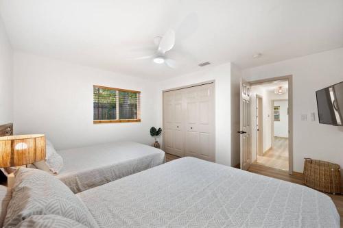 a bedroom with two beds and a ceiling fan at King Beds - Game Room - Pool - Beach 2m - 2,100sqft in Largo