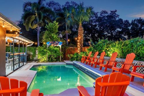 a swimming pool with orange chairs around it at King Beds - Game Room - Pool - Beach 2m - 2,100sqft in Largo
