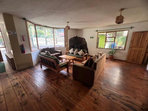 a living room with two couches and a table at La Casa Verde Eco Guest House in Baños