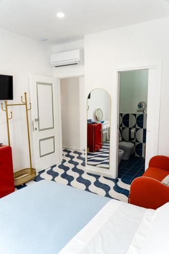 a bedroom with a mirror and a red chair at Blu D Alia Exclusive Rooms in Ischia