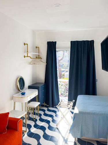 a bedroom with a bed and a desk and a window at Blu D Alia Exclusive Rooms in Ischia