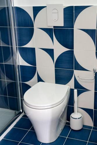 a toilet in a bathroom with blue and white tiles at Blu D Alia Exclusive Rooms in Ischia