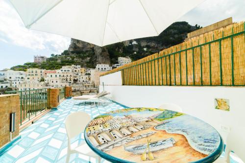 a balcony with a table and an umbrella at Palazzo Colavolpe Suite in Atrani