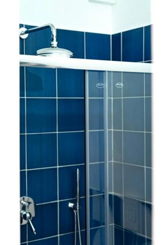 a blue tiled bathroom with a shower and a sink at Blu D Alia Exclusive Rooms in Ischia