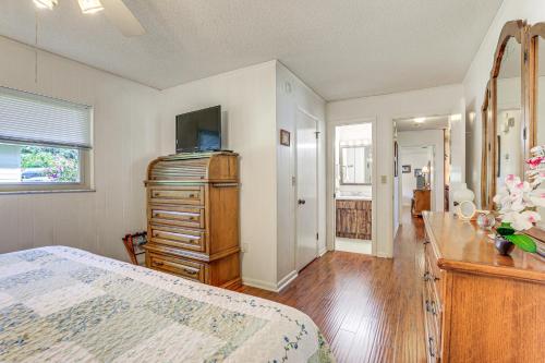 a bedroom with a bed and a dresser and a mirror at Lakefront Frostproof Vacation Rental with Beach! in Frostproof