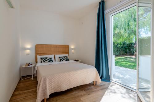 a bedroom with a bed and a sliding glass door at Villa Leomaris in Torre dell'Orso