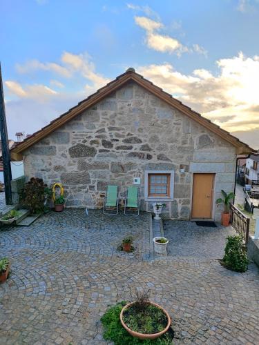a stone building with two chairs in front of it at Casa da Avó in Cetos