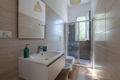 a white bathroom with a sink and a shower at Villa Leomaris in Torre dell'Orso