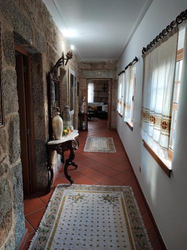 a hallway with a tile floor and a table and windows at Casa da Avó in Cetos