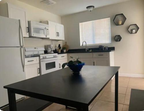 a kitchen with a black table and a refrigerator at Rest in Vegas in Las Vegas