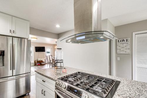 a kitchen with a stove top oven next to a refrigerator at Renovated Brainerd Cabin on Lake Fish and Swim! in Brainerd