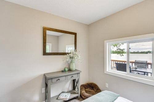 a bedroom with a mirror and a table and a window at Renovated Brainerd Cabin on Lake Fish and Swim! in Brainerd