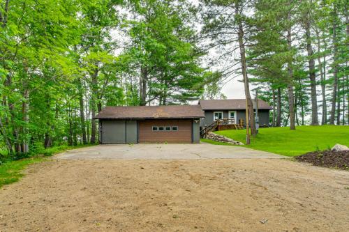a house with a garage in the middle of a dirt road at Renovated Brainerd Cabin on Lake Fish and Swim! in Brainerd