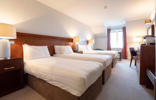 a hotel room with two beds and a desk at Schull Harbour Hotel & Leisure Centre in Schull