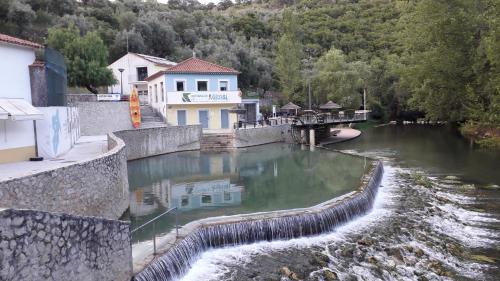 a river with a building and a bridge over it at Quinta Da Silva in Vale dos Ovos