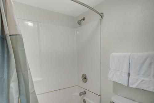 a white bathroom with a shower and white towels at Motel 6-Lima, OH in Lima