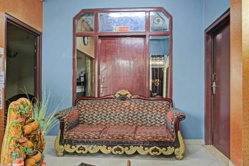 a couch sitting in a room with a window at Hotel O Aashiyana Home in Dibrugarh