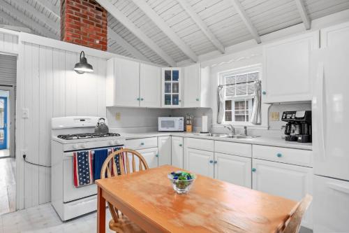 a kitchen with white cabinets and a wooden table at 17 Captain Dunbar Road Brewster - Prestons Haven in Brewster