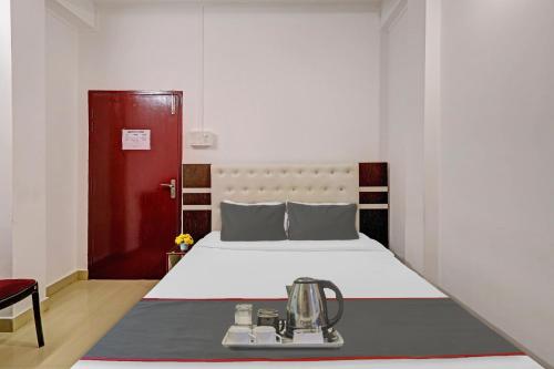 a bedroom with a bed and a red door at Hotel O Aashiyana Home in Dibrugarh
